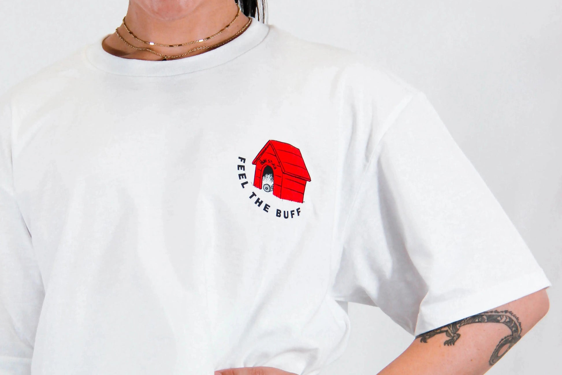 Close-up of the dog house graphic on the front of the Classic Graphic Buff Tee, part of the unique design inspired by Scoopy.