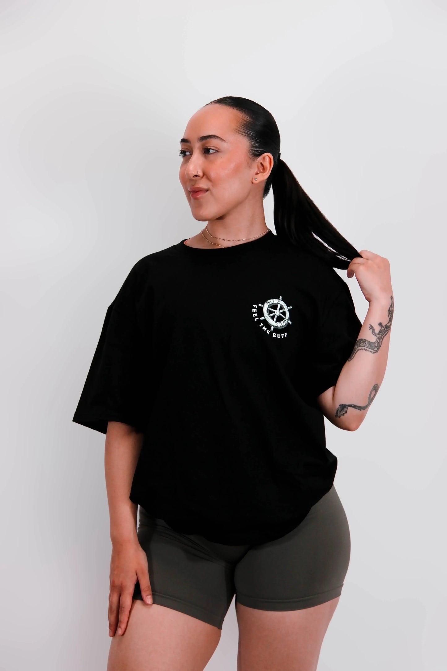 Front view of a model wearing the Classic Graphic Buff Tee, featuring the steering wheel graphic that complements the Steamy-Bod Willie design on the back.