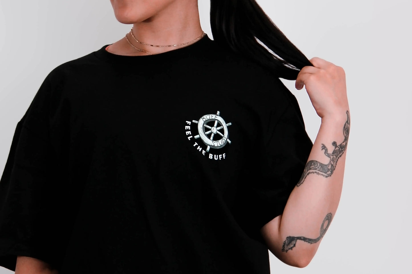 Close-up of the steering wheel graphic on the front of the Classic Graphic Buff Tee, part of the unique design inspired by Steamy-Bod Willie.