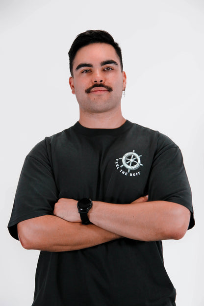 Front view of a model wearing the Premium Buff Cover, featuring the steering wheel graphic that complements the Steamy-Bod Willie design on the back.