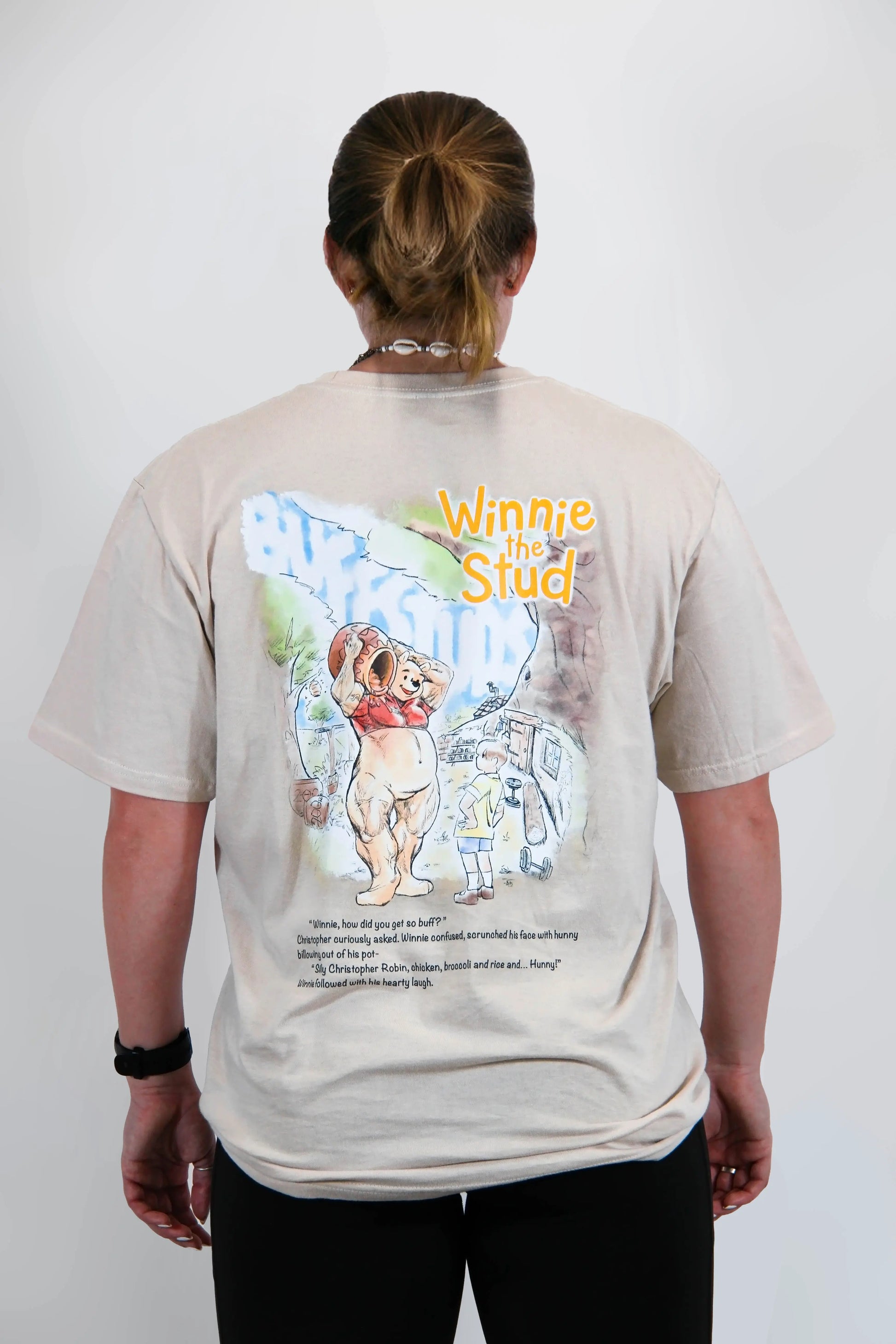 Back view of a model wearing the Classic Graphic Buff Tee, showcasing the unique Winnie the Stud graphic design.