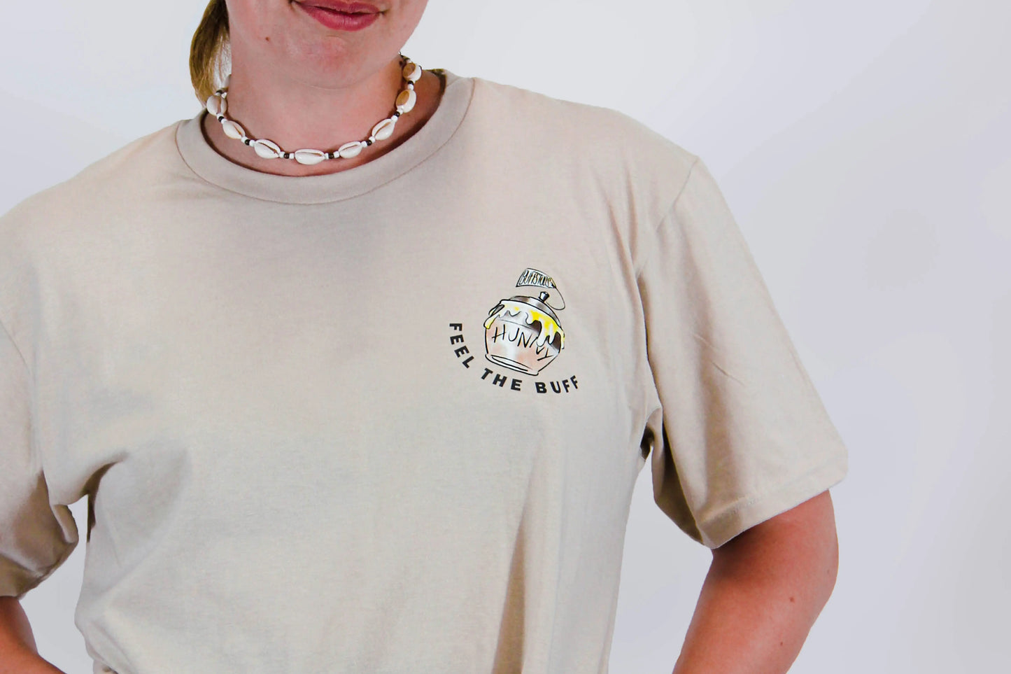 Close-up of the pot of Hunny graphic on the front of the Classic Graphic Buff Tee, part of the unique design inspired by Winnie the Stud.