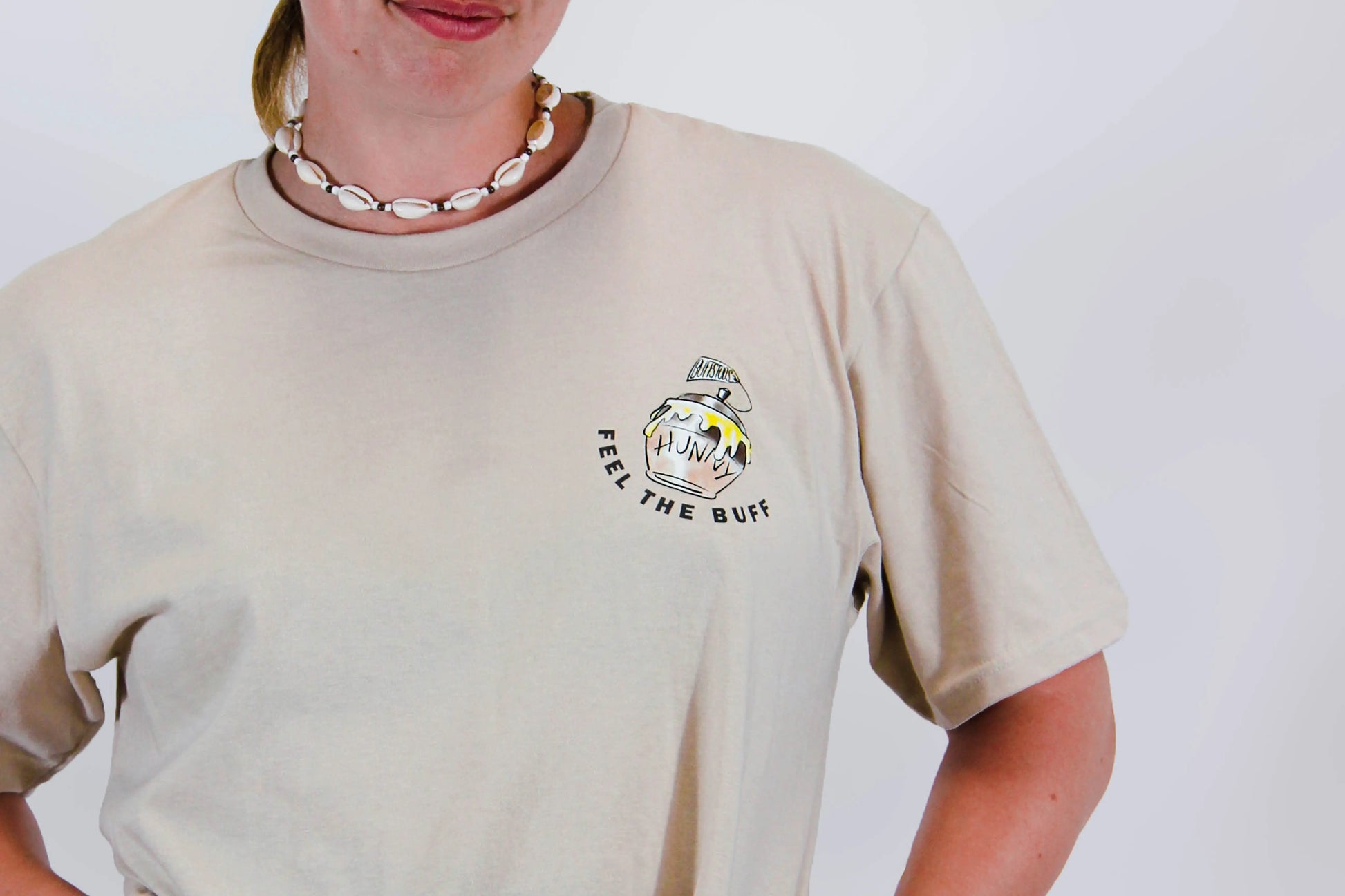 Close-up of the pot of Hunny graphic on the front of the Classic Graphic Buff Tee, part of the unique design inspired by Winnie the Stud.
